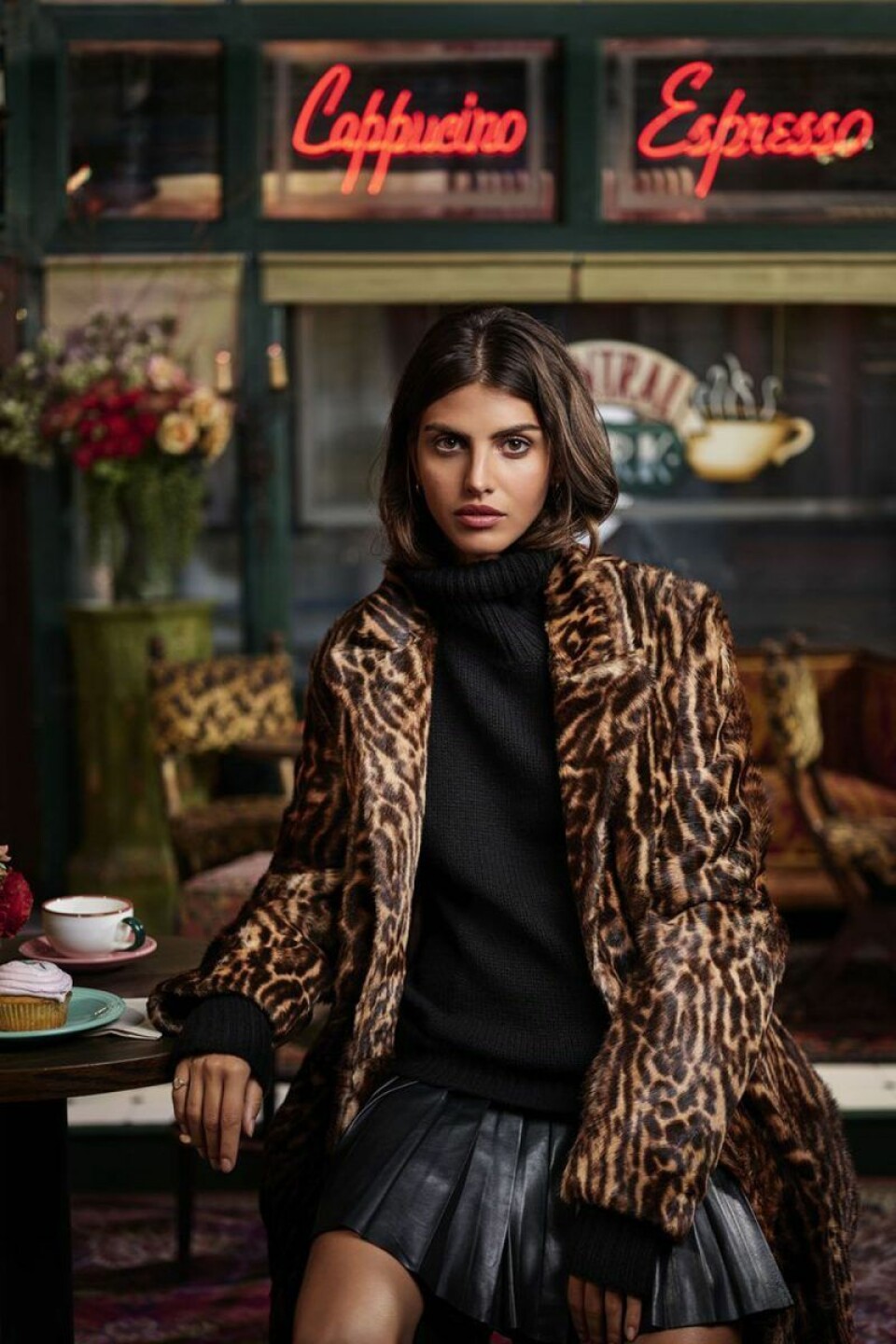 Typisk Rachel-outfit: Veckkjol, polotröja och djurmönstrad jacka. Fotograferad i Central Perk-miljö. Foto: Ralph Lauren Typisk Rachel-outfit: Veckkjol, polotröja och djurmönstrad jacka. Fotograferad i Central Perk-miljö. Foto: Ralph Lauren